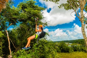 A woman ziplining in the jungle with Alltournative Mayan Offtrack Adventures, near Riviera Maya, Mexico.